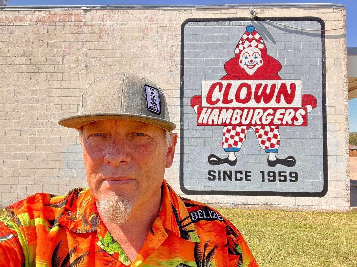 Willis Odell in front of the wall sign in 2022 after he and Renee Medford bought Clown Burger in Haltom City. The sign was painted over by remodeling crews Jan. 19, 2024.