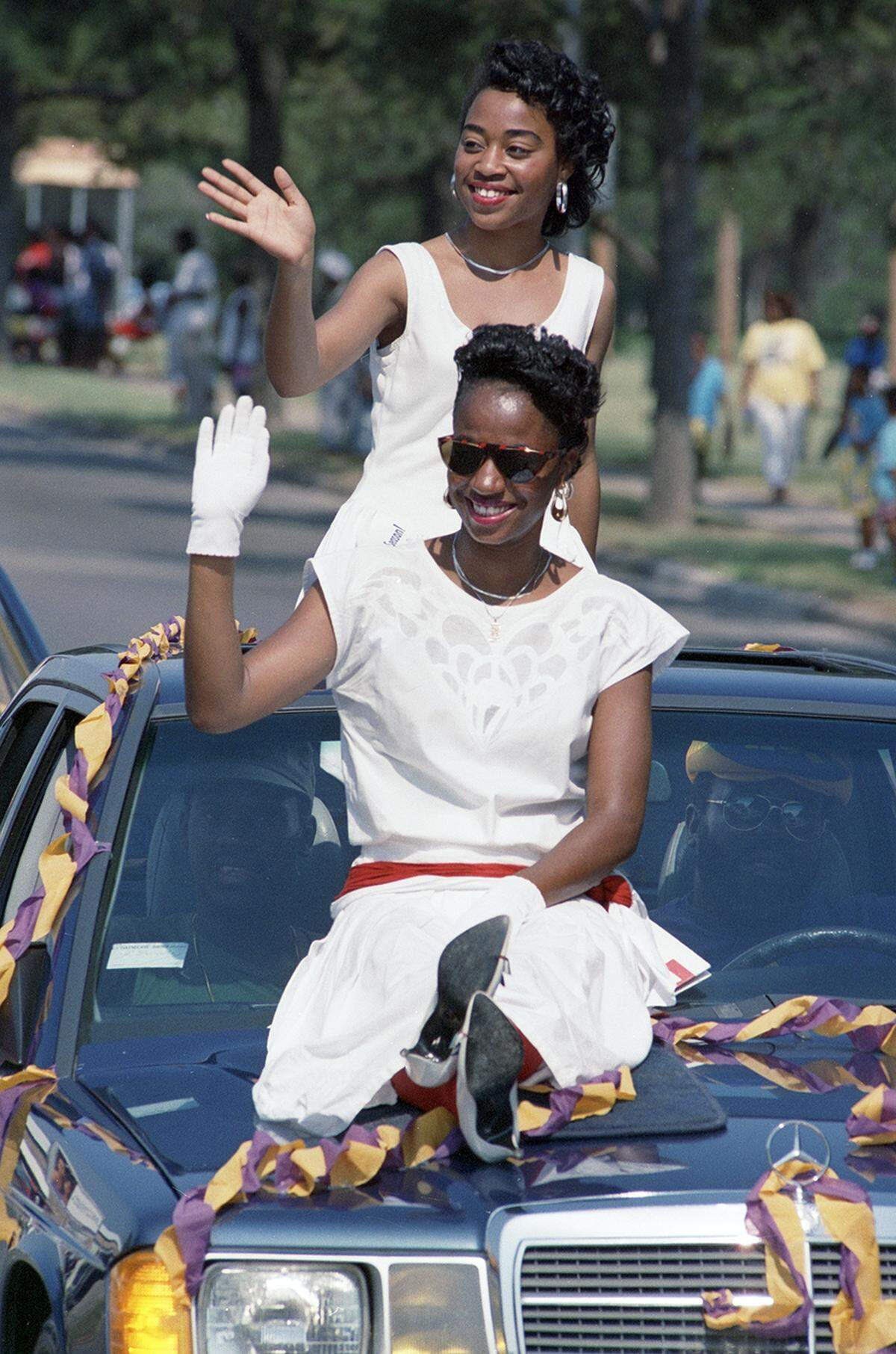 Carla Geiger, front, and Sheila Hall wave to the crowd watching a 1988 Juneteenth parade along Rosedale Street in Fort Worth.