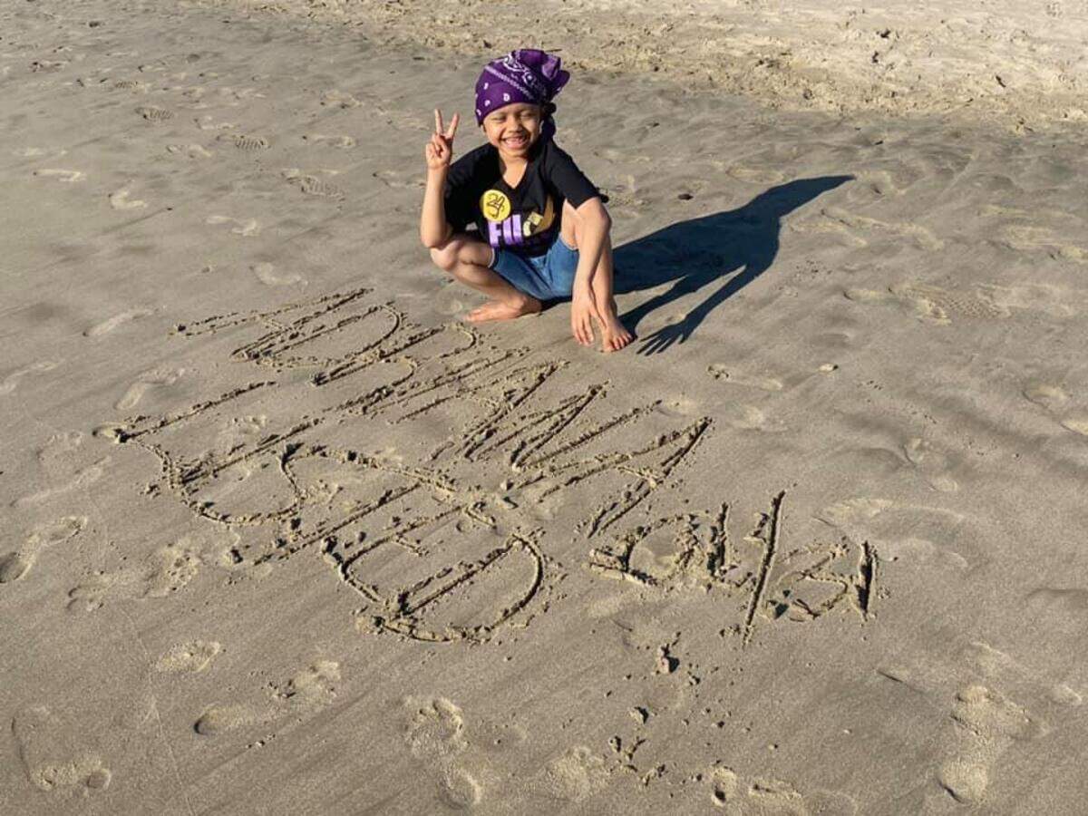 Adriana Nixon, 6, poses by a message in the sand of the beach by the Santa Monica Pier reading, “Adriana Nixon. Listed.” Her parents found out she would be listed for a liver as they were preparing to board their plane to Los Angeles.