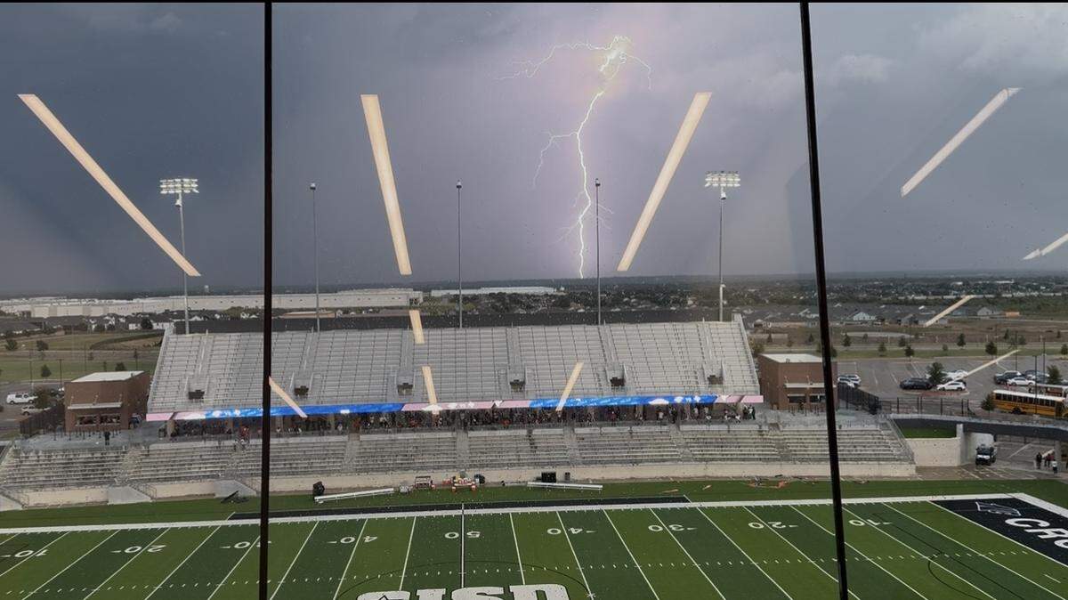 A lightning strike is seen around Crowley ISD Stadium during a weather delay. North Crowley and Lancaster were set to play in a non-district game in Fort Worth, Texas, on Thursday, Aug. 28, 2025.