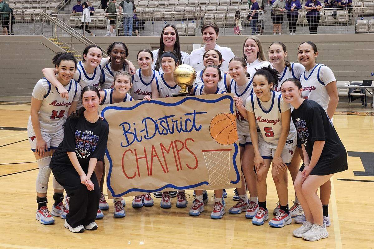 The Grapevine Mustangs pose with hardware after defeating Fort Worth Chisholm Trail in a UIL girls Class 5A Division II bi-district game on Monday, February 16, 2026 at Thomas Coliseum in Haltom City, Texas.