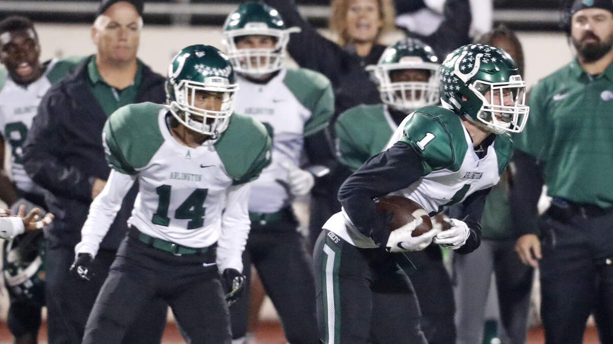 Arlington defensive back Tucker Thompson grabs an interception in front of the Arlington bench during the first half against Arlington Martin on Friday at UTA Maverick Stadium. Arlington won 32-25.