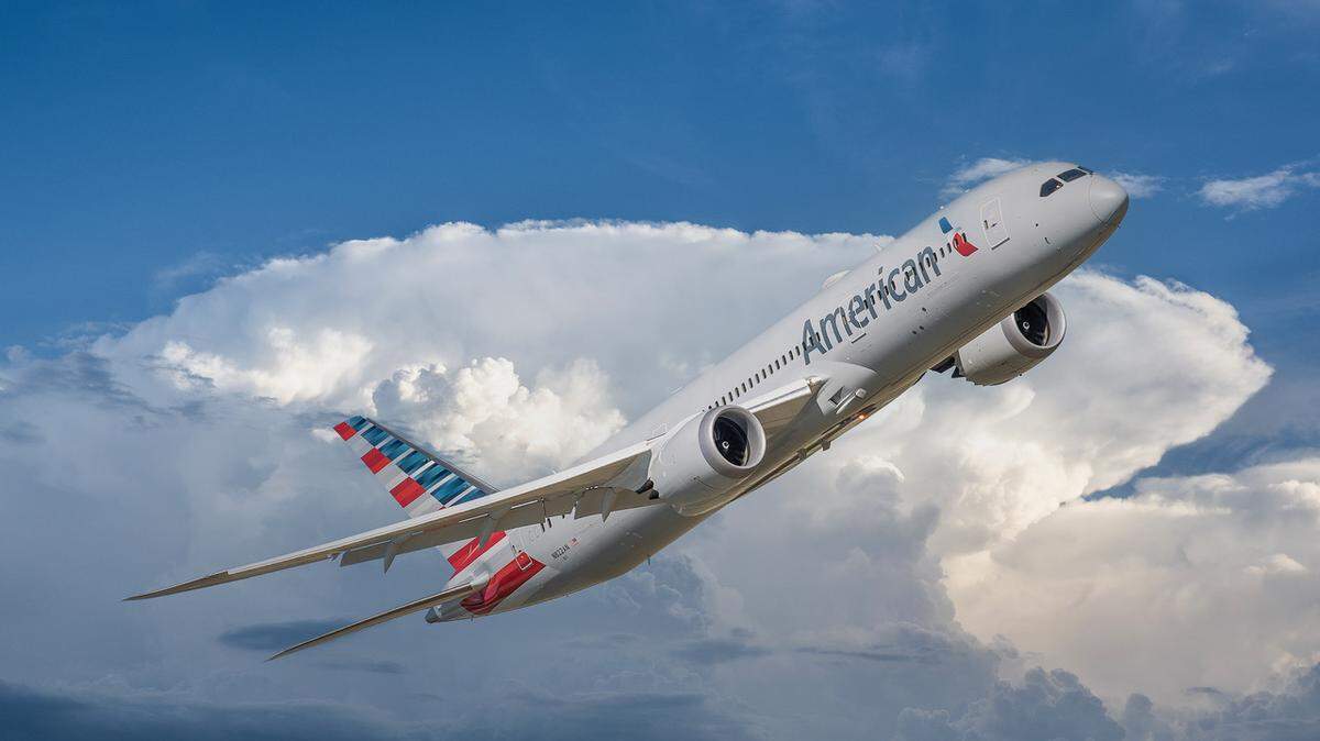 An American Airlines plane soars in the sky.