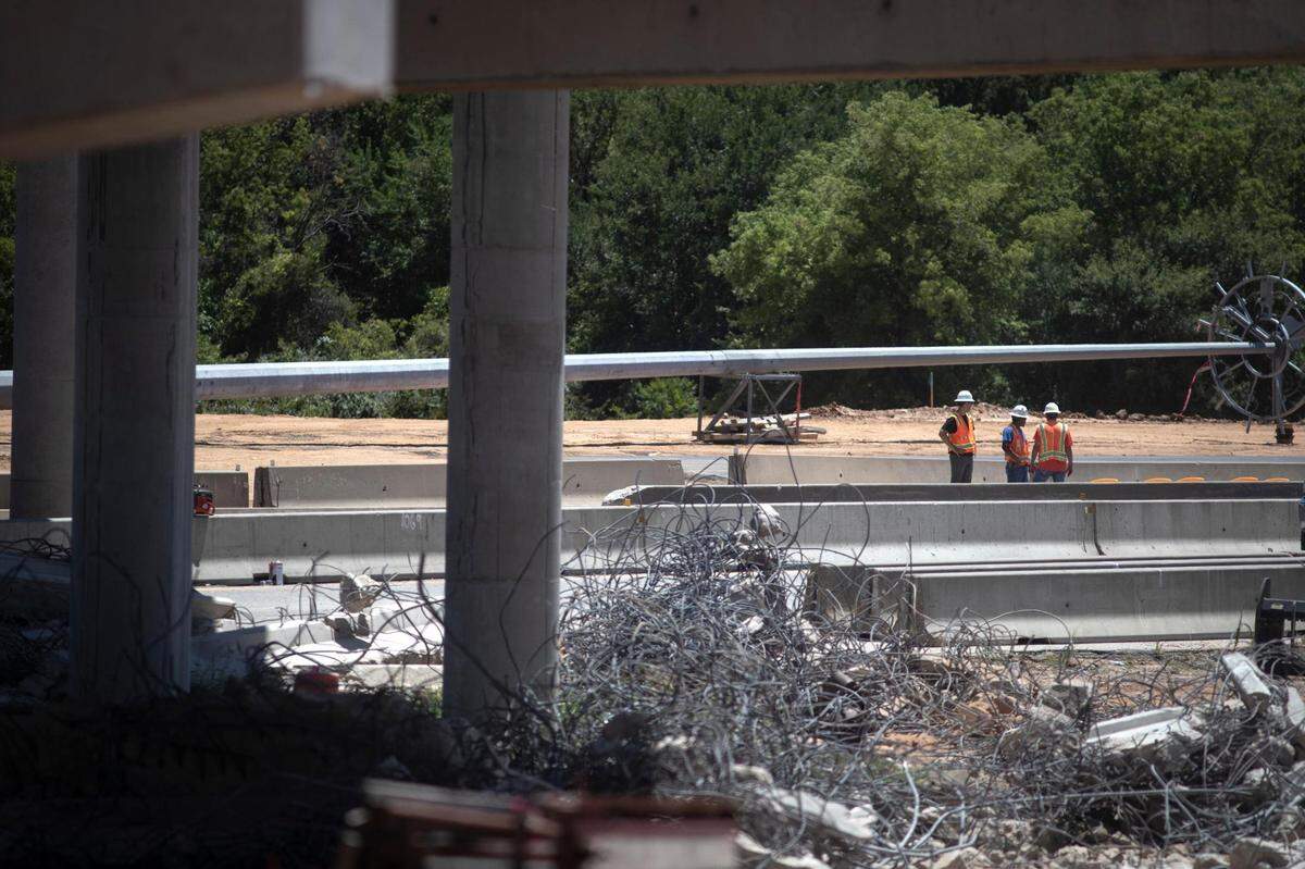 Workers oversee as demolition begins for the southbound Loop 820 bridge crossing over Texas 121 in Fort Worth, Texas, on Saturday, July 16, 2022. Multiple detours bypassed motorists around the ongoing construction.