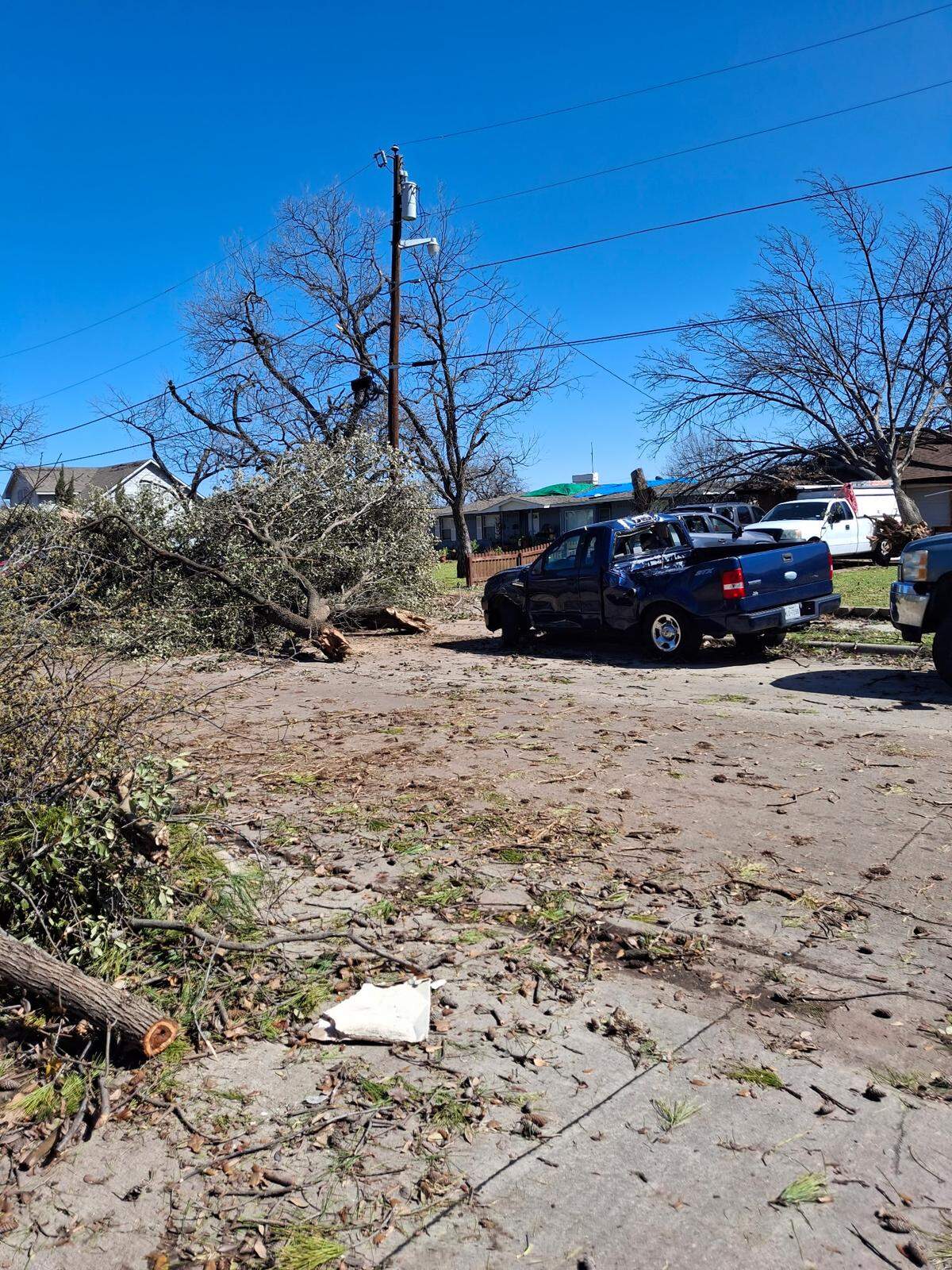 Part of a tree across the street flew several feet and landed in Eugenio Ruiz’s driveway in Irving on Tuesday, March 3. It damaged one of his vehicles.