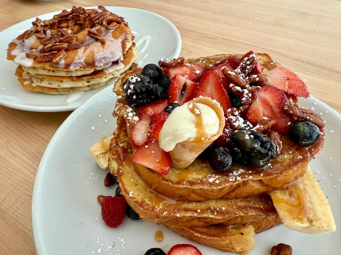 Banana split French toast, foreground, and cinnamon roll pancakes with pecans at Eggsquisite Cafe in west Fort Worth, April 13, 2025.