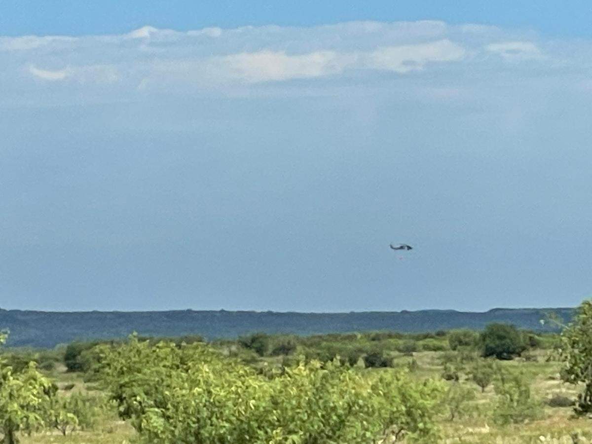 Blackhawk military helicopters equipped with fire suppression capabilities are helping fight a wildfire in Palo Pinto County.