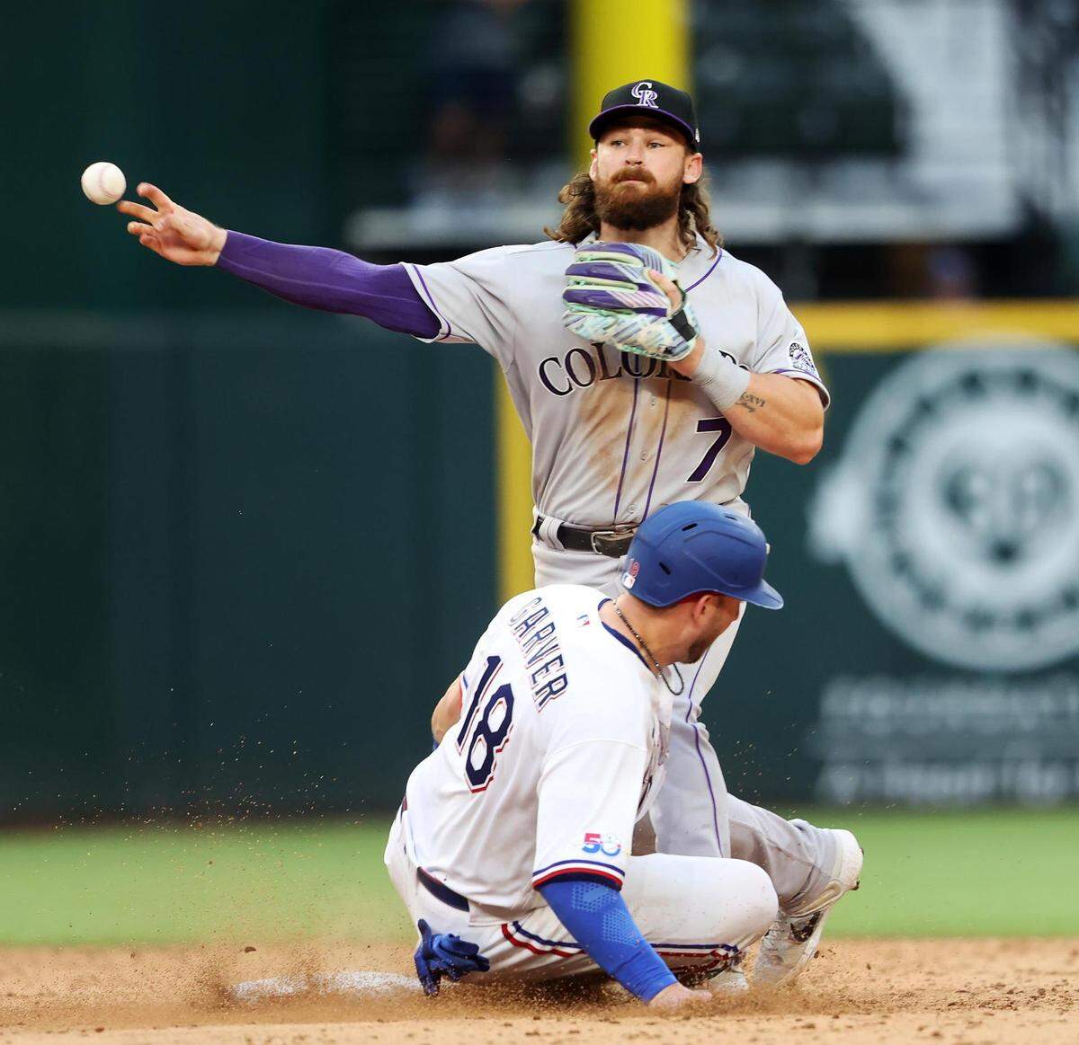Texas Rangers catcher Mitch Garver slides into Colorado Rockies’ Brendan Rodgers during the bottom of the 10th inning on Monday, April 11, 2022, at Globe Life Field. After review the play at second base was found to be in violation of the slide rule, handing the Rockies a 6-4 win over the Rangers.