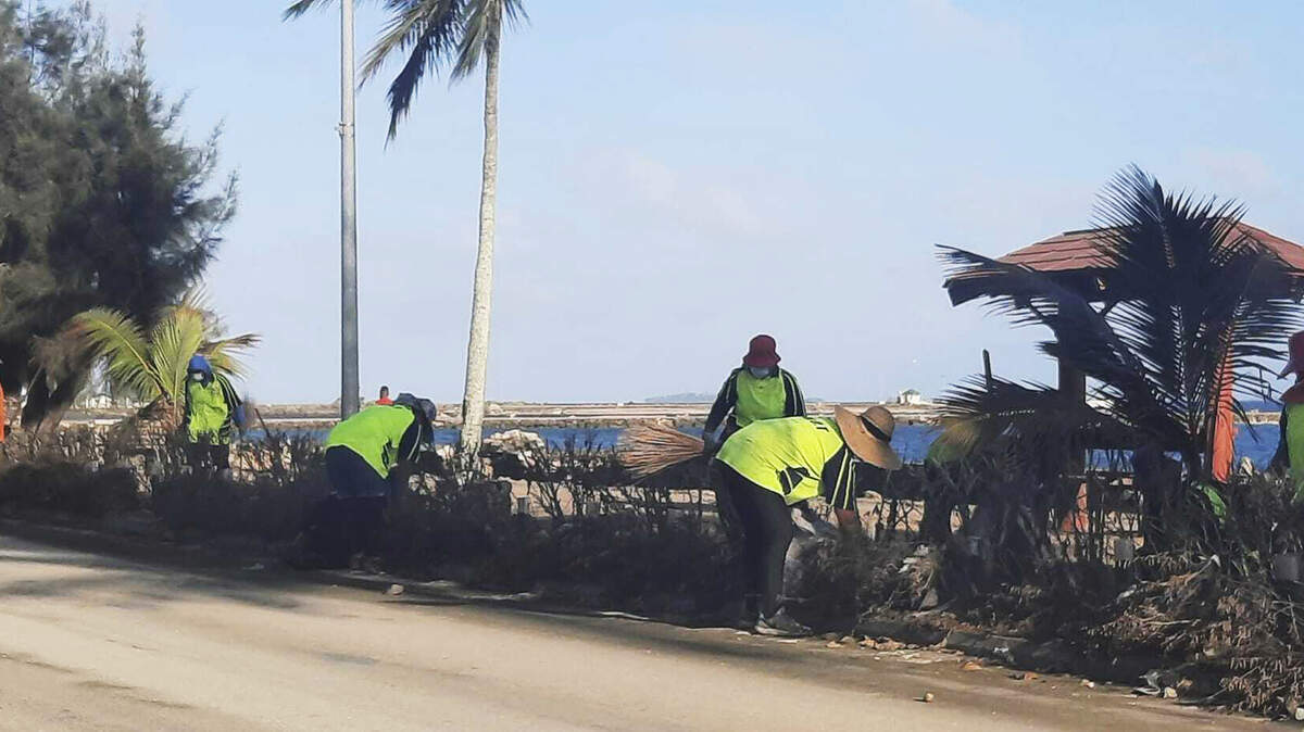 In this photo provided by Broadcom Broadcasting, people clear debris off the street in Nuku’alofa, Tonga on Thursday following Saturday’s volcanic eruption near the Pacific archipelago.