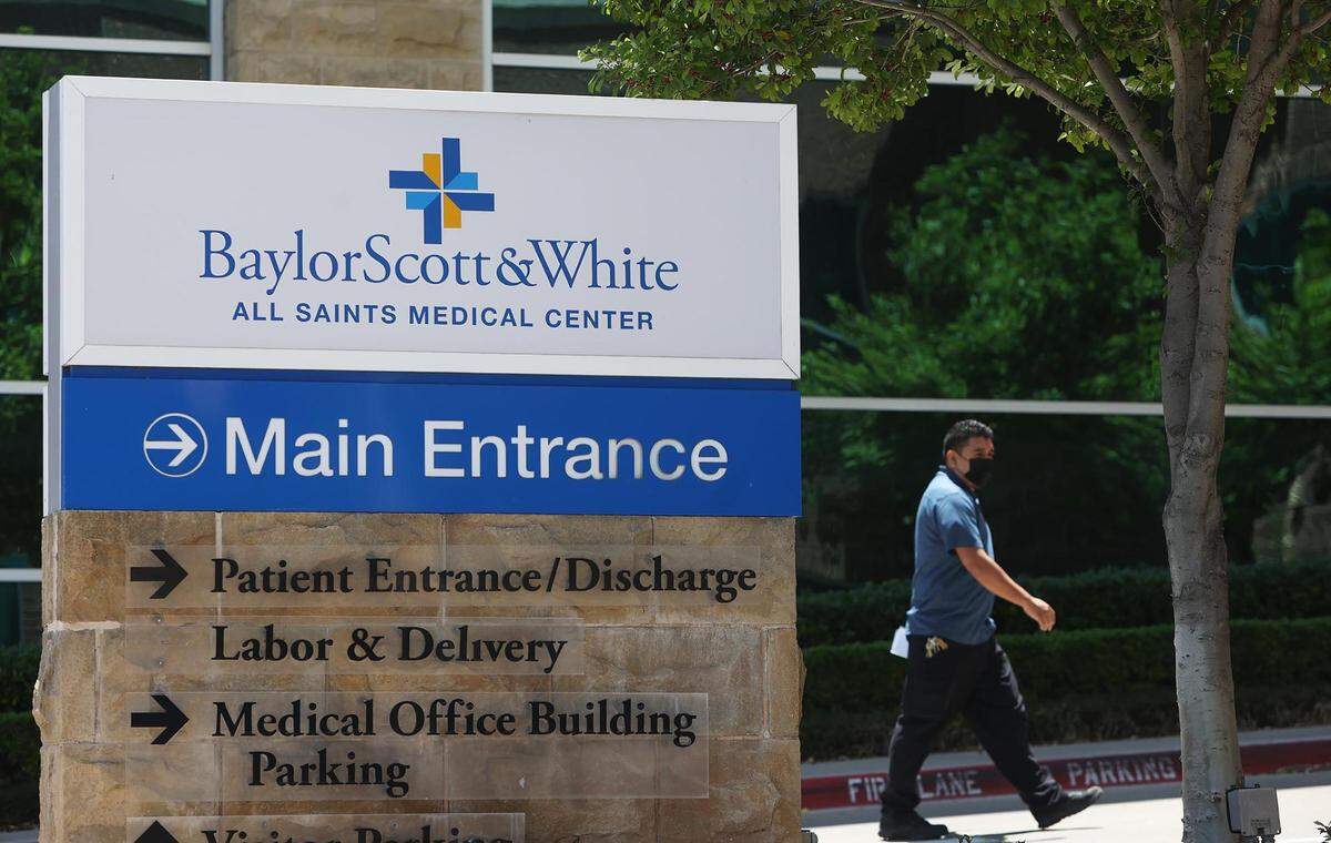 A man walks towards the main entrance of Baylor Scott & White All Saints Medical Center on Thursday in Fort Worth.