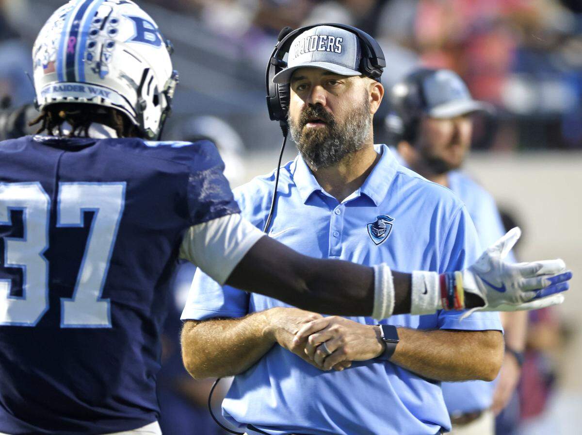 L.D. Bell head coach TJ Dibble talks with outside linebacker Imani Reynolds (37) after the defense received a penalty during the second half of a UIL football game between Carroll and L.D. Bell at Pennington Field in Bedford, Texas, Friday, October, 24, 2025.