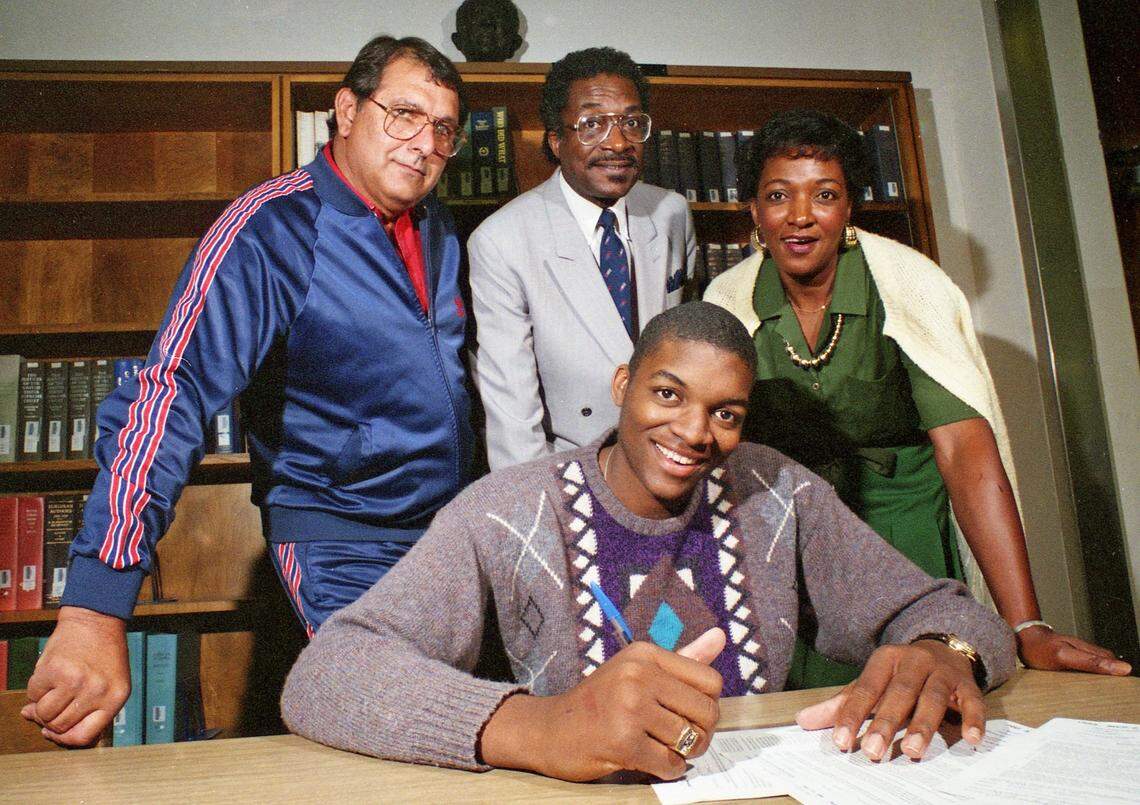 Southwest High School basketball player Oliver Miller Jr. signs a letter of intent in April of 1988, to attend the Universityof Arkansas. With him are Southwest coach James Wood, his father Oliver Miller Sr. and mother Annie Miller.