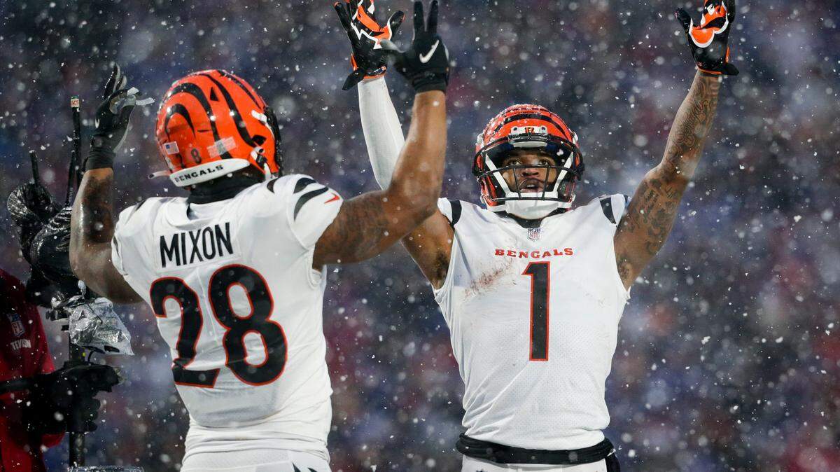 Cincinnati Bengals wide receiver Ja’Marr Chase (1) and Cincinnati Bengals running back Joe Mixon (28) motion for a touchdown against the Buffalo Bills during the third quarter of an NFL division round football game, Sunday, in Orchard Park, N.Y.