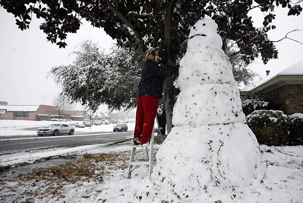 Chris Cook of Arlington, a Boston native, complete a statuesque snowman in the front lawn of his home near Young Jr. High in Arlington on Thursday, February, 11, ,2010. He says it took about 2 1/2 hours.