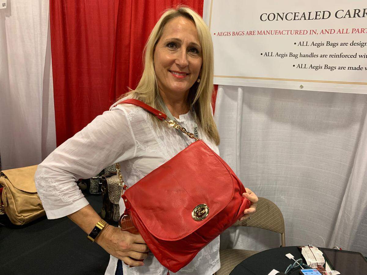Abby Walker, owner/designer of Aegis handbags, demonstrates the first bag she designed for concealed handgun carry.