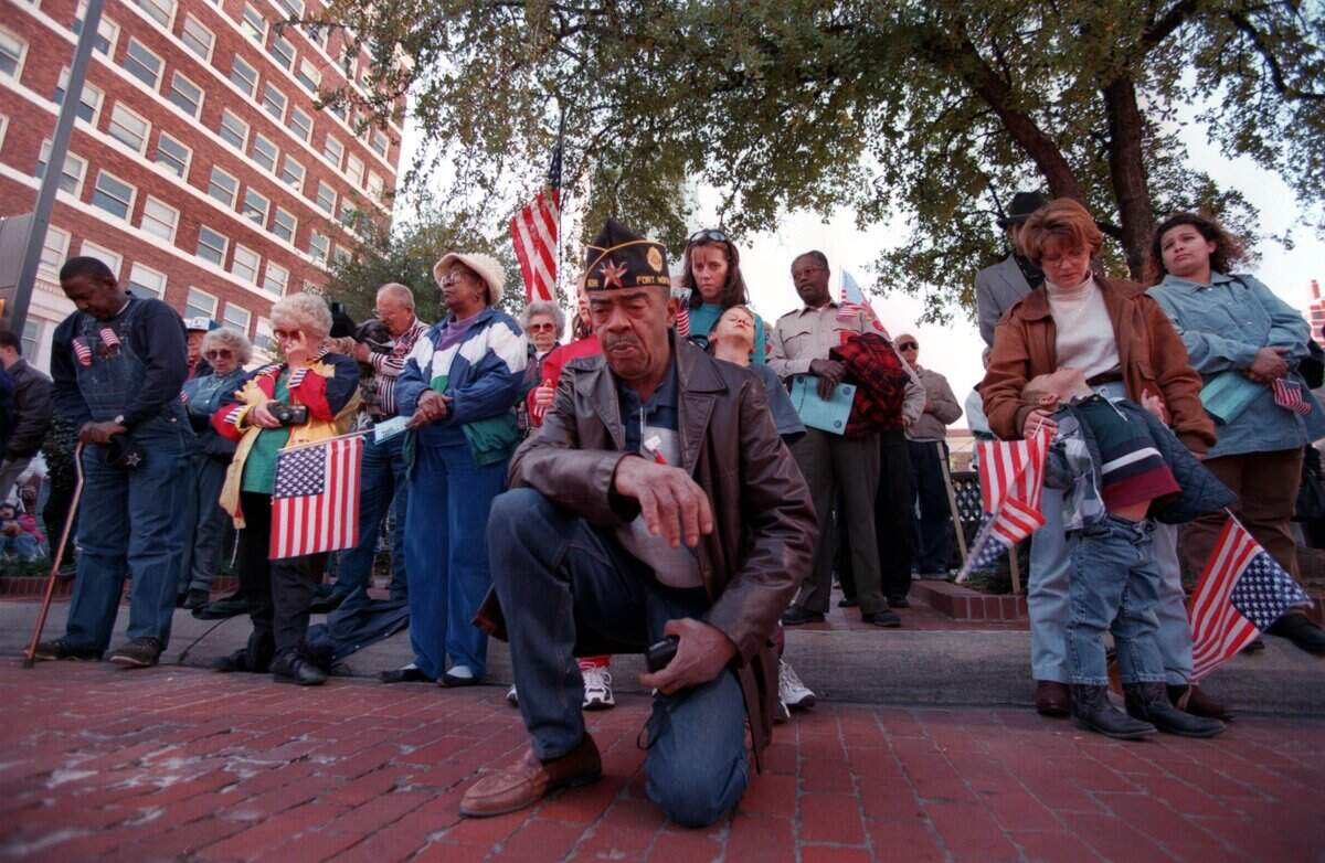 Nov. 11, 1998: Parade-goers pause for a silent salute as they line up on Main Street during the Tarrant County Veterans Day parade in downtown Fort Worth.