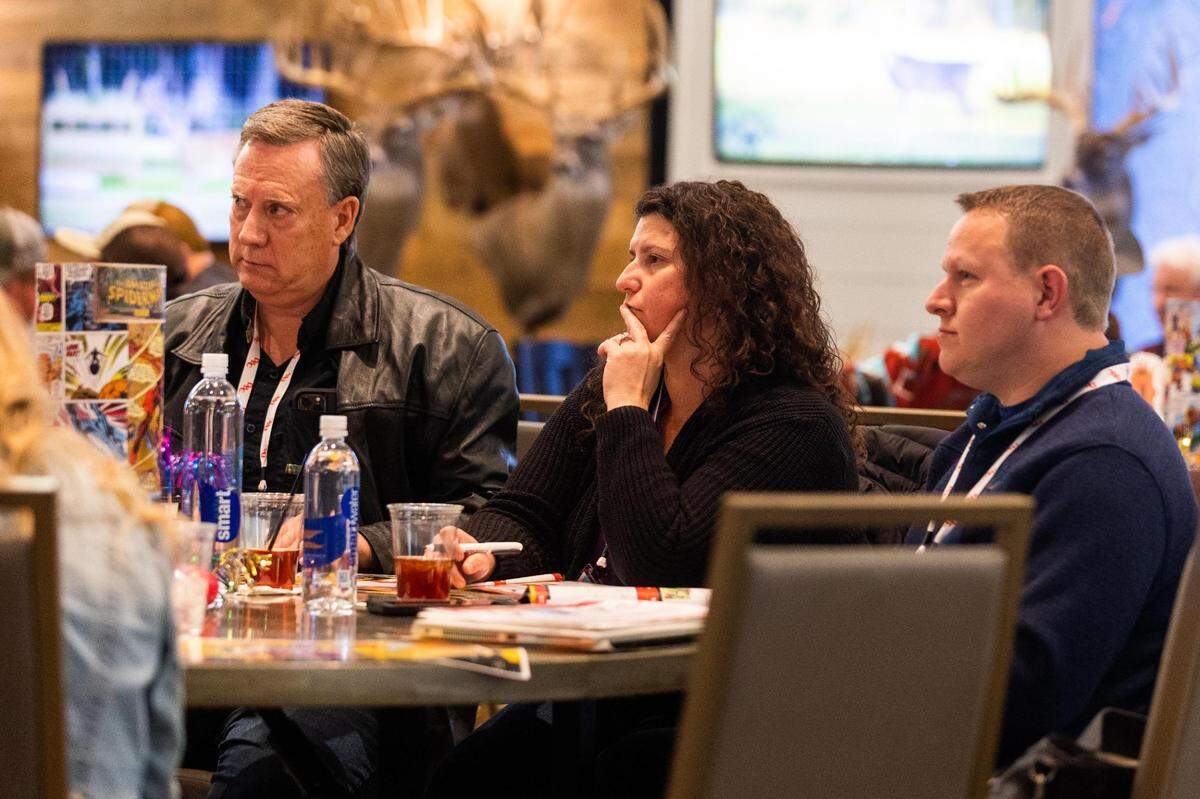 Erich Ramsey, Jessica Lawson and Ashton Lawson listen to the auctioneer during the Deer Breeding Corp.’s January 2022 auction at Horseshoe Bay Resort.