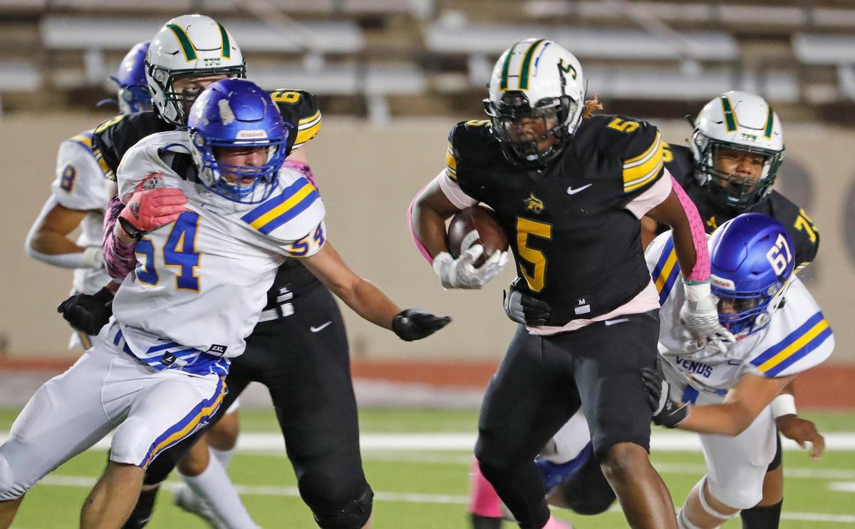 Benbrook running back Jaylon Williams (5) avoids the tackle of Venus lineman Patrick Wilson (67) as he passes lineman Conner Watkins (54) in the first half of a Division II 4-4A high school football game at Farrington Field in Fort Worth, Texas, Thursday, Oct. 13, 2022. Benbrook led Venus 28-0 at the half. (Special to the Star-Telegram Bob Booth)
