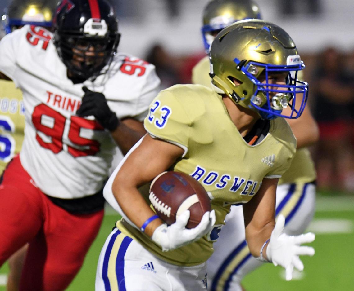 Boswell’s Ezra Carter, right, runs past Trinity’s Jordan Williams for a first down in the first quarter of Friday’s September 16, 2022 District 3-6A football game at Boswell High School Pioneer Stadium in Fort Worth, Texas. Special/Bob Haynes