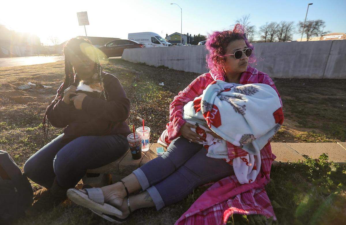 Meaghan Jackson, left, holds her sister’s cat, Sophia, while sitting with her mother, Marilyn Cole, and 2-year-old daughter as the Fort Worth Fire Department battles a fire at their apartment complex on Wednesday, February 26, 2020.