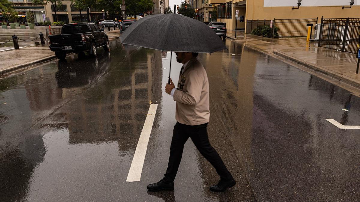 Michael McDonald crosses the street in the rain on Houston Street in downtown Fort Worth on Tuesday, Sept. 3, 2024.