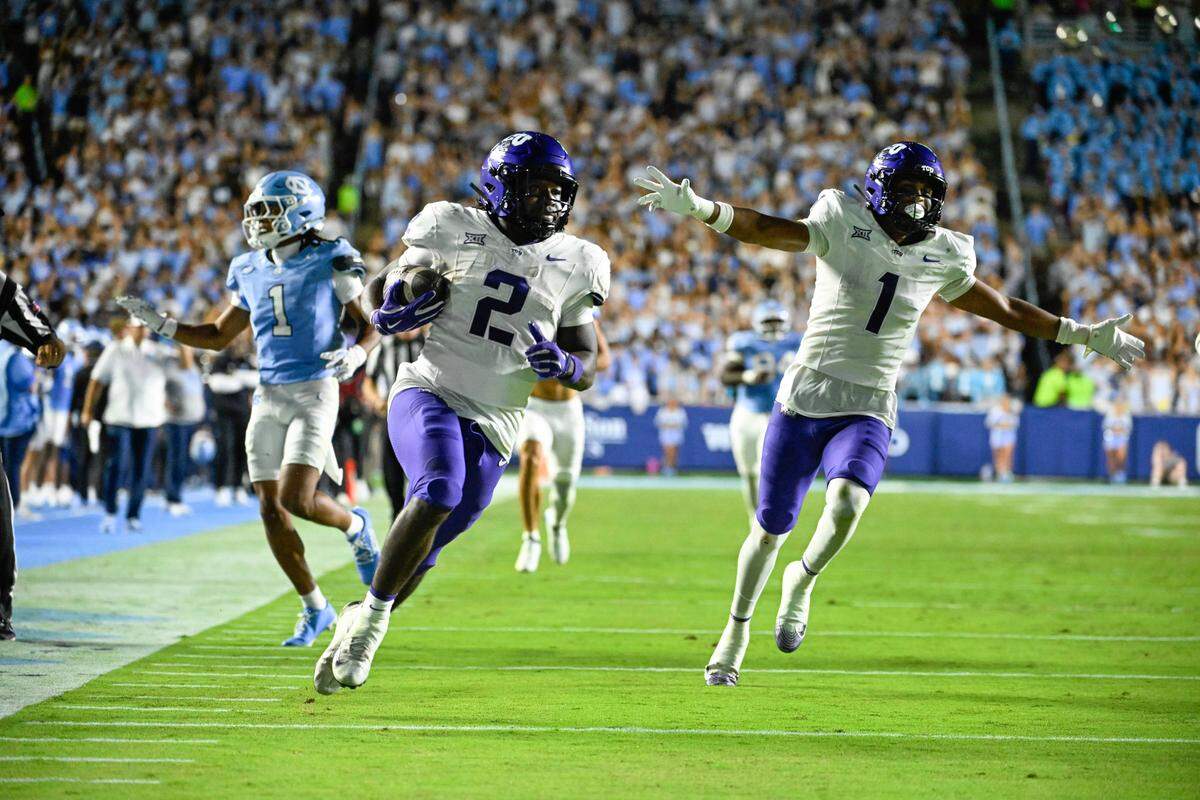Sep 1, 2025; Chapel Hill, North Carolina, USA; TCU Horned Frogs running back Kevorian Barnes (2) scores a touchdown as safety Austin Jordan (1) celebrates and North Carolina Tar Heels defensive back Thaddeus Dixon (1) defends in the third quarter at Kenan Stadium. Mandatory Credit: Bob Donnan-Imagn Images