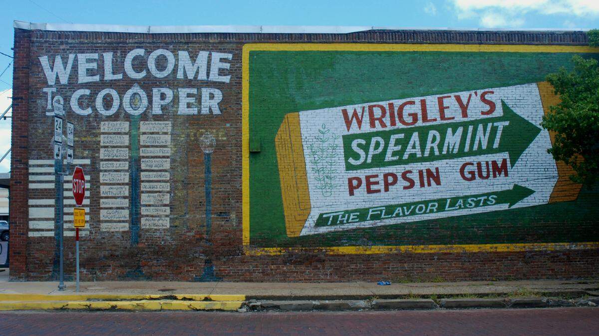 A painted mural, photographed on July 12, 2019, advertises Wrigley’s gum and locals businesses, many no longer in operation, off the main square in Cooper, Texas, in Delta County, which has a population of around 2,000 people.