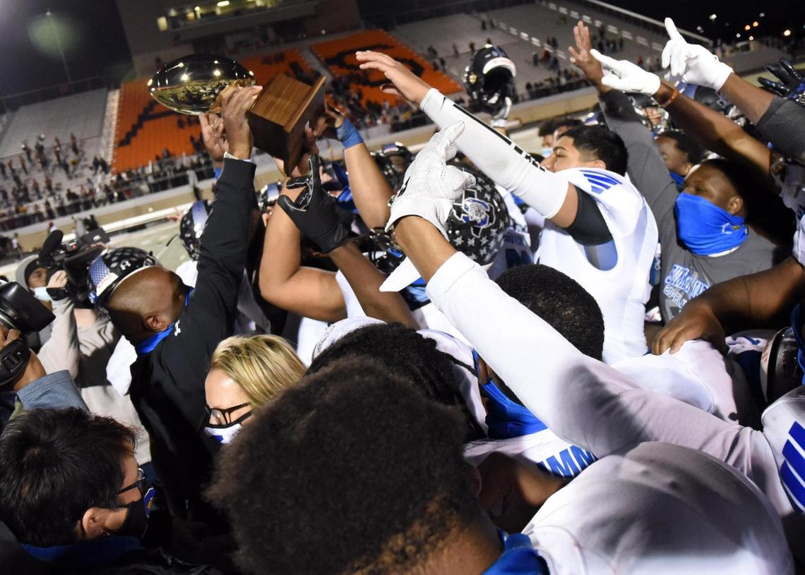 Mansfield Summit’s Coach Channon Hall, left holds the trophy as he and his team celebrate their 34-31 win over Colleyville Heritage in their Division 1-5A Regional Round Play-off football game Saturday, December 26, 2020 at Bearcat Stadium in Aledo, Texas. Special/Bob Haynes