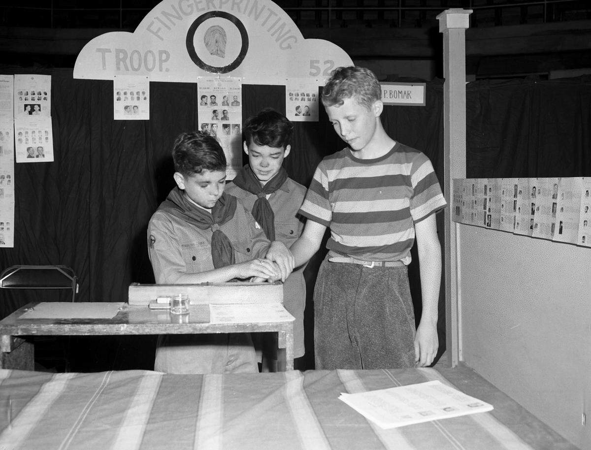 May 1, 1943: The Boy Scouts are holding the Merit Badge Show and Demonstration of Scouting War Skills at Will Rogers Memorial Coliseum. One of the many skills on display is fingerprinting. Scout Bobby Thomas, left, is making prints of Bill Pumphrey, while Scout Billy McLean, center, observes.