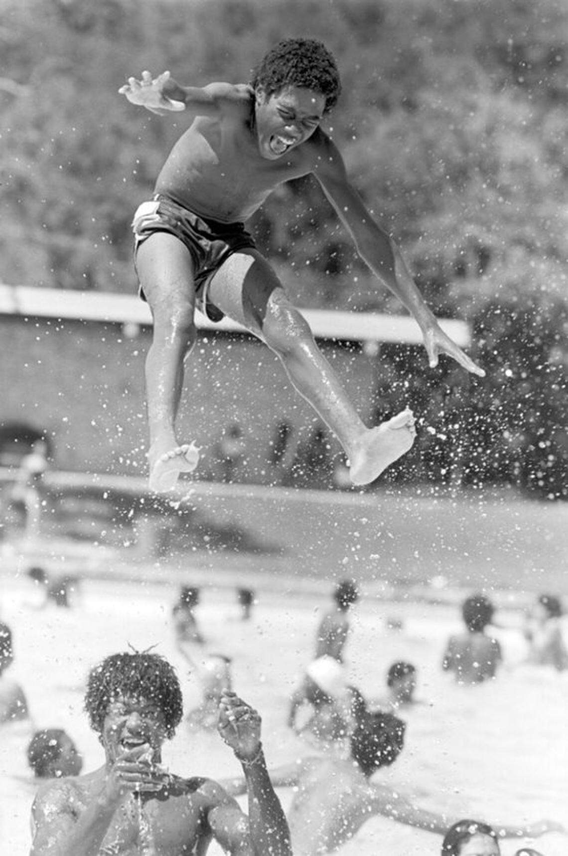 Swimmer Willie Brooks is hoisted into mid-air above the water at the Forest Park Pool on June 7, 1981. 