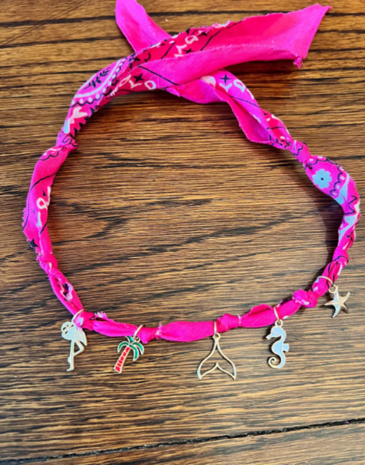 A pink bandanna necklace made and sold by Fort Worth children with connections to Camp Mystic and Central Texas is shown. More than 300 necklaces have been sold online through Hale House boutique for flood relief.