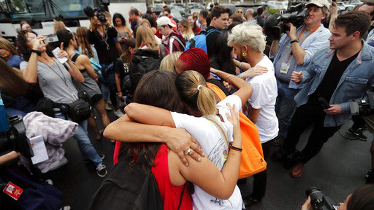 Student survivors from Marjory Stoneman Douglas High School, where 17 students and faculty were killed in a mass shooting on Wednesday, hug survivors of the Pulse nightclub shooting before boarding buses in Parkland, Fla., Tuesday, Feb. 20, 2018, to rally outside the state capitol and talk to legislators about gun control reform. Nikolas Cruz, a former student, was charged with 17 counts of premeditated murder on Thursday. (AP Photo/Gerald Herbert)