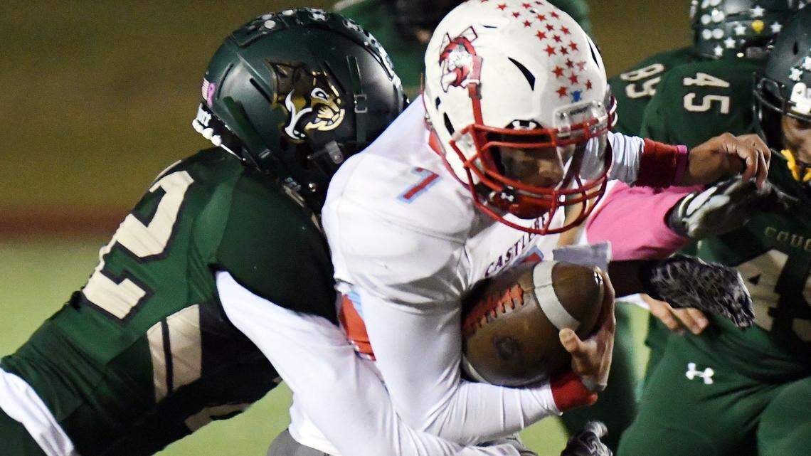 Western Hills’ Josh Davis, left, wraps up Castleberry quarterback Drew Aguillon after he races for a first down during the second quarter of Friday’s game at Farrington Field in Fort Worth.