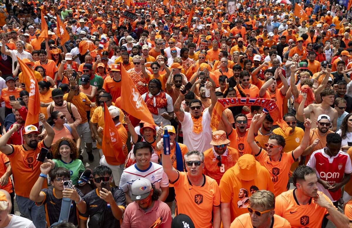 Netherlands soccer fans march to Dallas Stadium ahead of the FIFA World Cup match against Japan on Sunday, June 14, 2026 in Arlington, Texas. The famous double-decker Dutch Orange Bus, or De beroemde Oranjebus, is part of a Netherlands fan tradition bringing a sea of orange to the streets before major soccer matches.