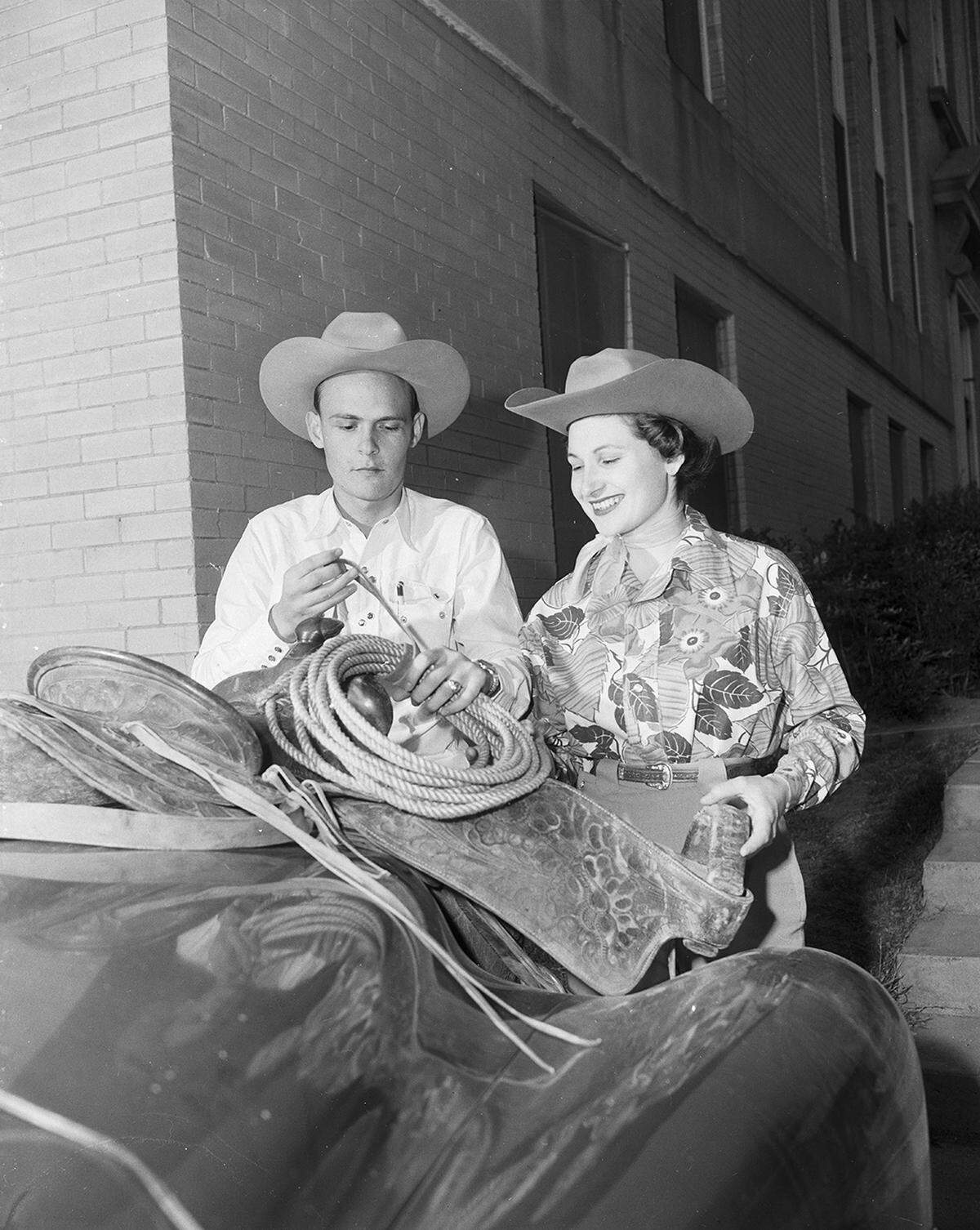 March 13, 1952: “Ranch Week at TCU has got everybody in Western costumes this week. TCU rodeo president Christmas Barber, a junior from Midland, puts finishing touches on his saddle as pretty Sylvia Bokor of Mission, this year’s Ranch Week queen, looks on.”