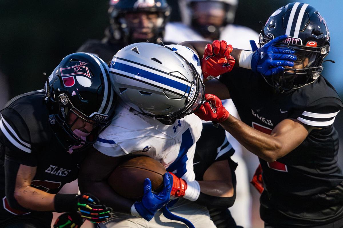 Burleson Centennial running back Jaxon Williams (4) has his facemark held by Burleson defender Jaden Thurston (7) in the first quarter of the 2024 Boot Bowl game against Burleson High School at BISD Stadium in Burleson on Friday, Aug. 30, 2024.