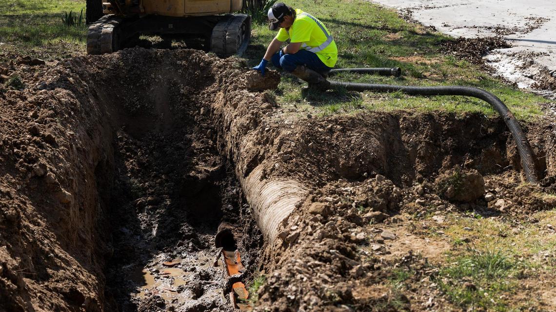 Runaway Bay public works employees work to replace a section of broken clay pipe after a clogged sewer line on Tuesday, March 25, 2025, after they responded to a clogged sewer line call. Runaway Bay has an outdated sewer system that threatens to spill sewage into Lake Bridgeport.