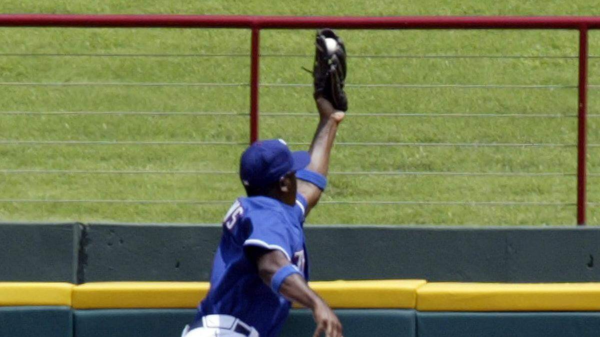 Rangers #14 Gary Matthews Jr. climbs the wall to rob Astros Mike Lamb of a homerun to end the eighth inning during the Texas Rangers vs Houston Astros Baseball game at Ameriquest Field in Arlington on Saturday July 1, 2006. The Rangers were shut-out 7-0. Fort Worth Star-Telegram/Sharon M. Steinman