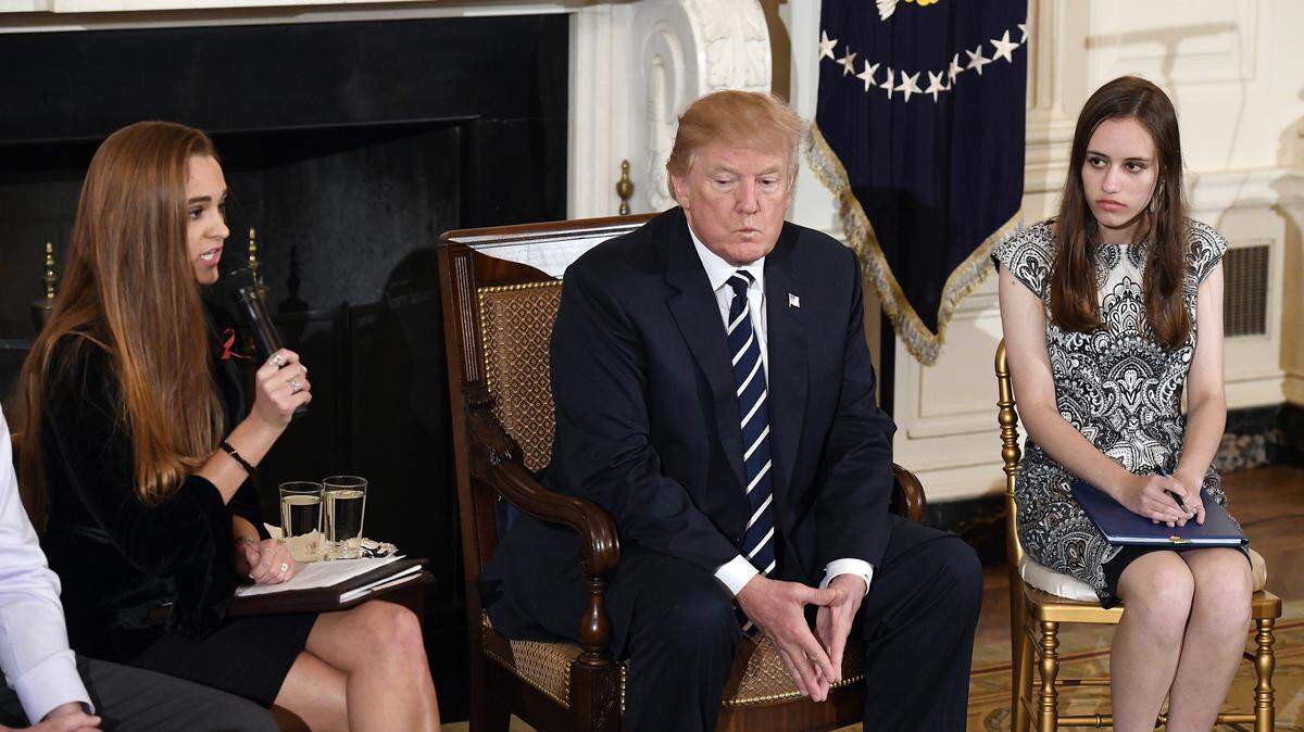 Julia Cordover, Marjory Stoneman Douglas High School student body president, speaks as President Donald Trump looks on during a meeting with students, parents and teachers affected by mass shootings in Parkland, Fla., Newtown, Conn., and Columbine, Colo., to search for policies to keep America's schools safe in the State Dining Room of the White House.