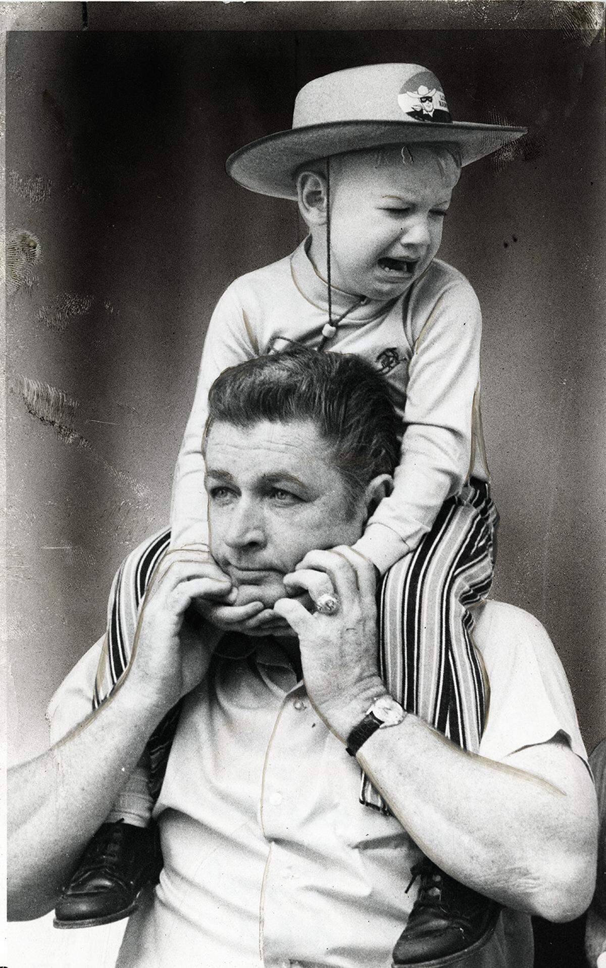 Circa 1971: Kevin Brown, 3, sits on father’s shoulders and cries during the Stock Show parade in downtown Fort Worth.
