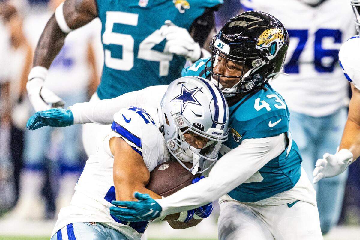 Dallas Cowboys running back Deuce Vaughn (42) gets wrapped up by Jacksonville Jaguars cornerback Kaleb Hayes (43) in the third quarter during the first preseason game between the Dallas Cowboys and Jacksonville Jaguars at AT&T Stadium in Arlington, Texas on Saturday, Aug. 12, 2023.