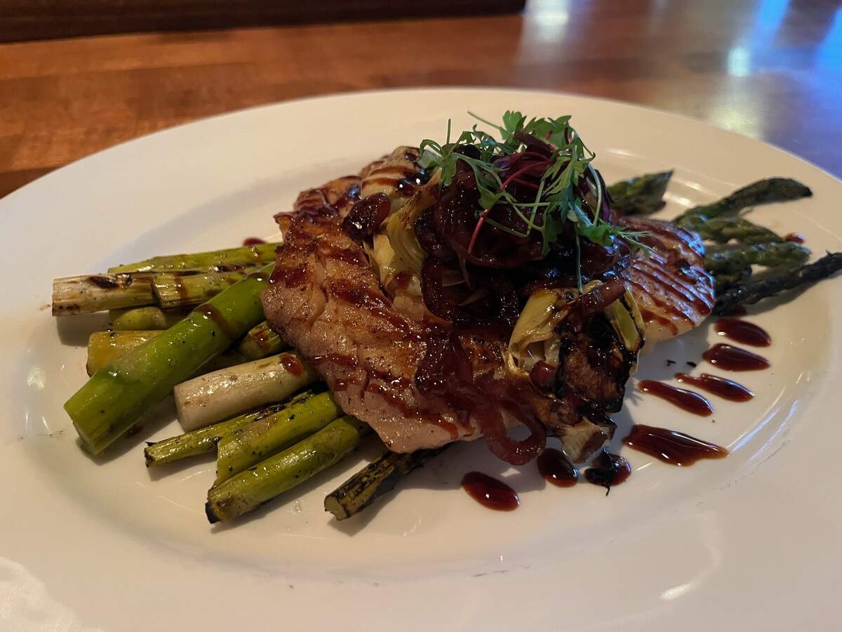 The Winewood Grill’s Pan Seared Snapper on a bed of grilled asparagus, topped with caramelized red onions and artichoke hearts, drizzled with balsamic reduction.