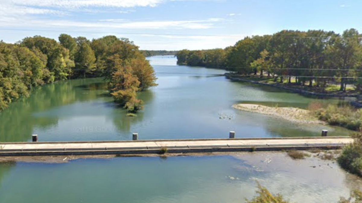 The photo shows an image of the Guadalupe River from a highway bridge in Kerrville, Texas.