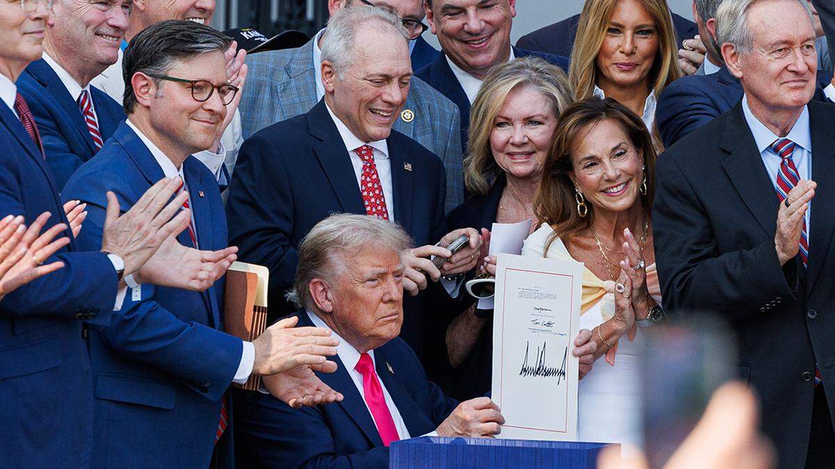 President Donald Trump signs his tax and spending bill into law during a 4th of July celebration with military families on the South Lawn of the White House in Washington DC, on Friday July 4, 2025. The â€˜One Big Beautiful Bill Actâ€™ cuts government spending and taxes and adds work requirements to medicaid, passed through both chambers of Congress in party-line votes. (Photo by Aaron Schwartz/Sipa USA)
