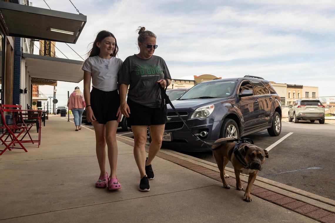 Jennifer Featherston, who has lived in Decatur for 14 years, walks her dog Daisy with her 11-year-old daughter Lily in the Decatur courthouse square on March 29, 2025. Featherston said she loves seeing new development in the city because it will cater to the younger families moving in.