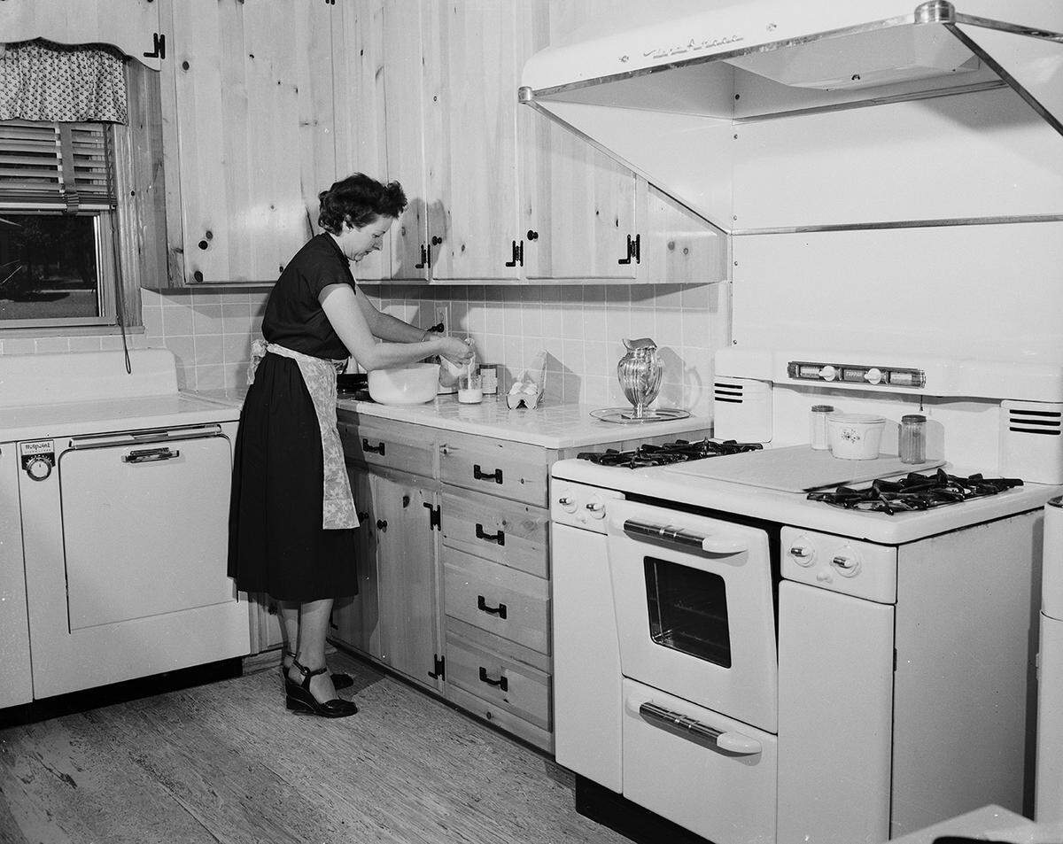 Sept. 18, 1951: Mrs. Jasper Hendrick has a kitchen so arranged that making a cake is a simple matter. The Hendricks live at 2193 Green Hill Circle. Mrs. Hendrick is shown cooking in her kitchen.