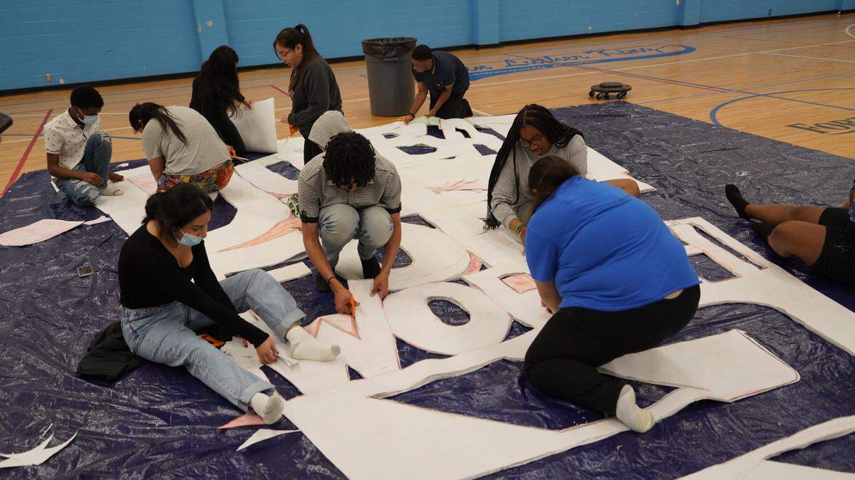 Dunbar High School students cut out of pieces for the world’s largest paper snowflake.
