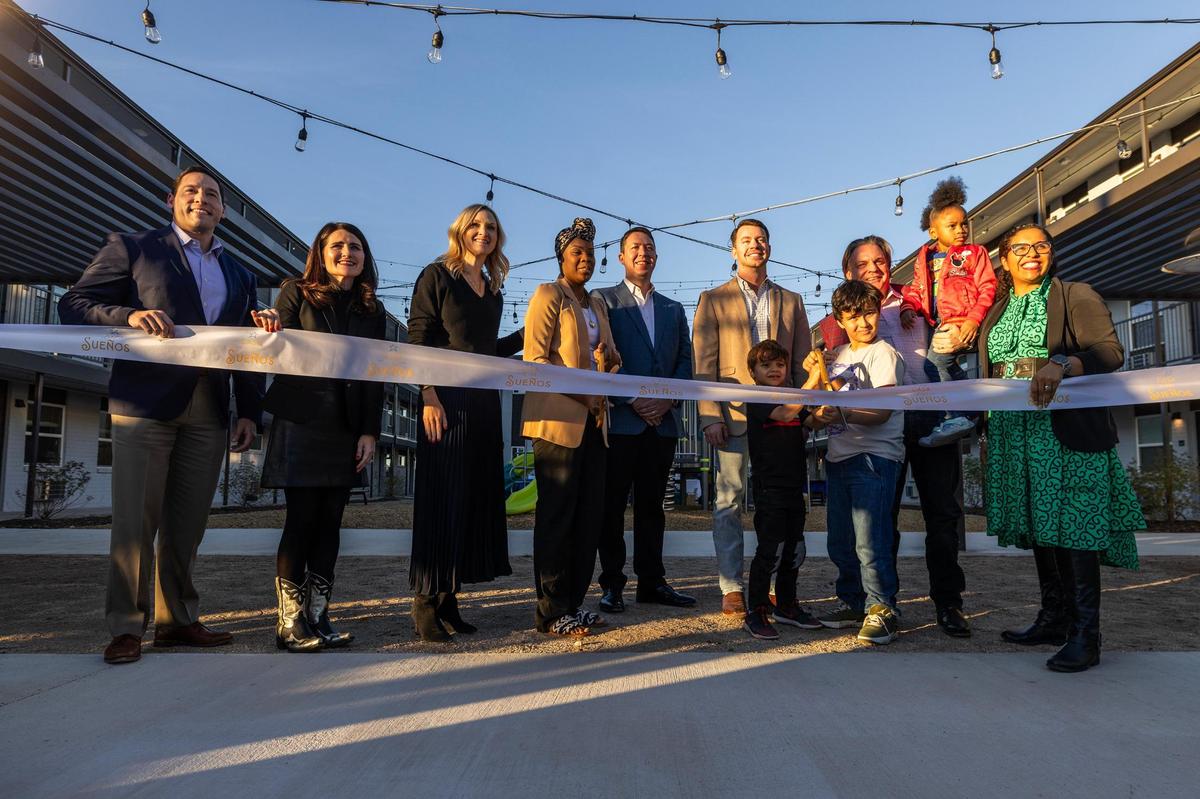 Fort Worth and Tarrant County officials, dignitaries and residents prepare to cut the ribbon for the grand opening of the Casa de los Sueños apartments in Fort Worth on Wednesday, Dec. 11, 2024.
