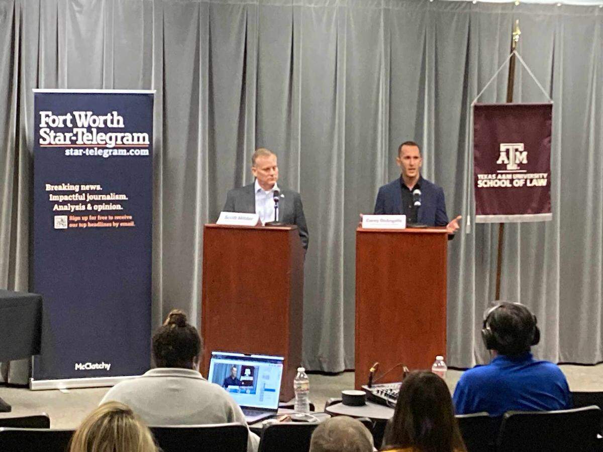 Two men stand behind brown lecterns on a dais. Banners for the Fort Worth Star-Telegram and the Texas A&M University Scool of Law hang on either side of them.