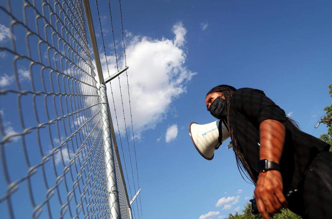 Activist Shenita Cleveland stands outside the gates of FMC Carswell on Saturday, August 1, 2020, while protesting conditions inside the federal medical prison during the COVID-19 pandemic.